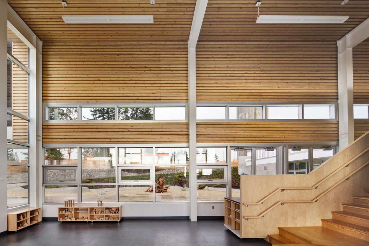 Walls and ceiling nail-laminated timber (NLT) panels, made from salvaged wood affected by the mountain pine beetle infestation, create a corrugated surface that adds visual interest and improves the acoustics of the busy UniverCity Childcare Centre activity spaces