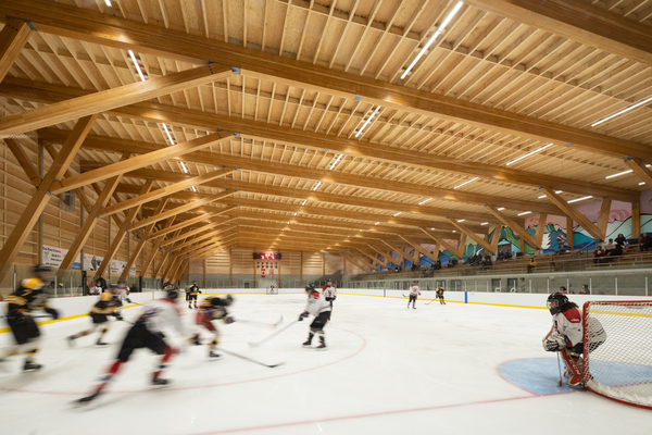 Glue laminated timber beams and columns support the roof in this interior view of the Upper Skeena Recreation Centre during a hockey game