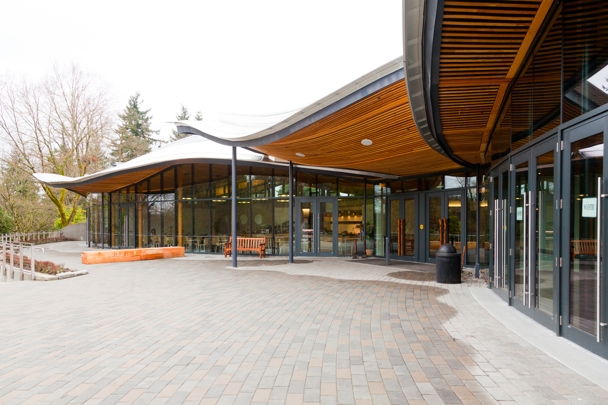 Exterior cloudy daytime image of the VanDusen Botanical Garden Visitor Centre highlighting swooping timber roof design made possible through precise prefabricated technology