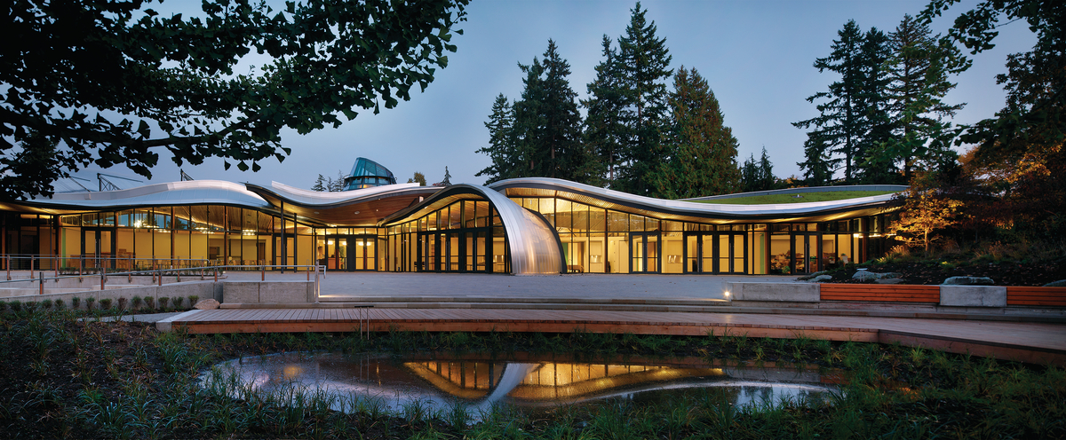 Exterior cloudy early evening image of the VanDusen Botanical Garden Visitor Centre highlighting swooping timber roof design made possible through precise prefabricated technology
