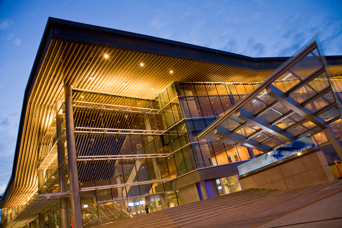 Exterior evening view of the multi storey low rise Vancouver Convention Centre West Building showing extensive use of mass timber, interior and exterior paneling, trim, and exterior glazing