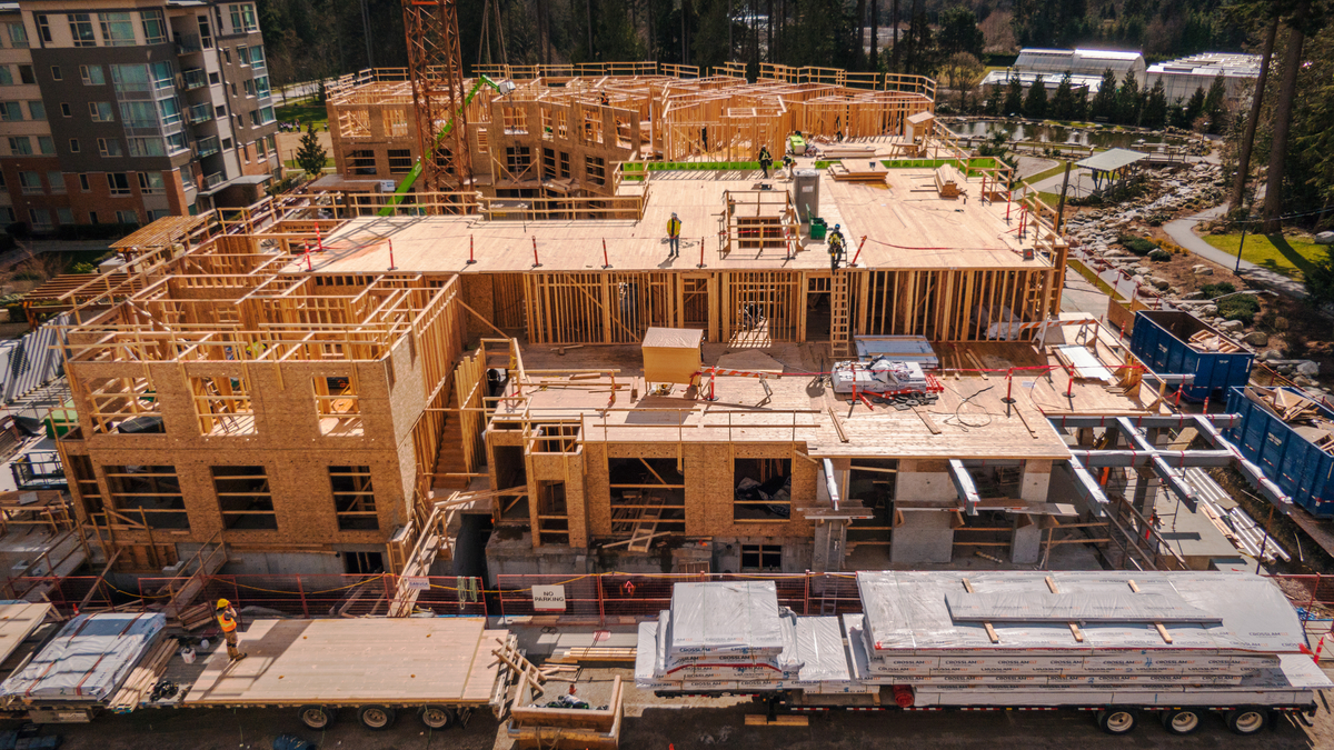 Outdoor daytime aerial upper floor image of hybrid multi family residential Virtuoso building during construction showing light frame construction and cross-laminated timber (CLT) floor panels