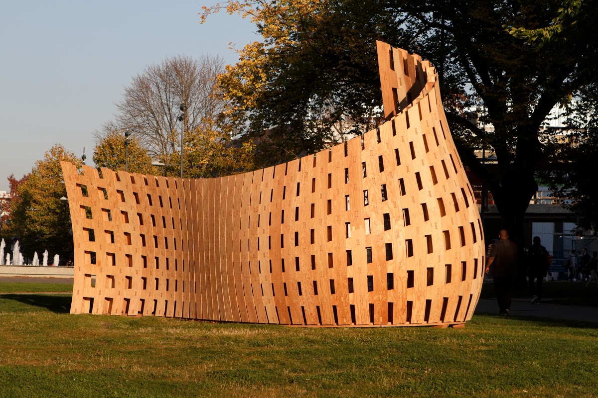 Robotically fabricated wooden wall in a curved, wavy and organic form.