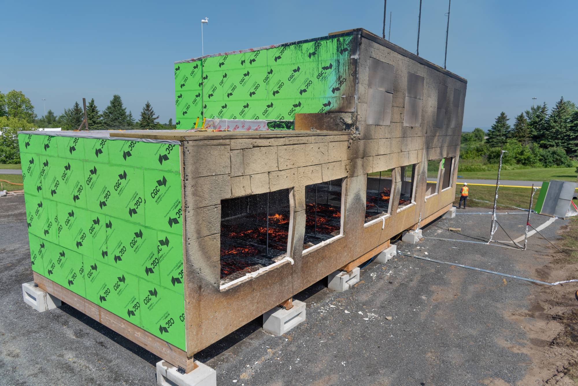 Mass timber building in the late stages of fire testing, with smoldering in the interior.