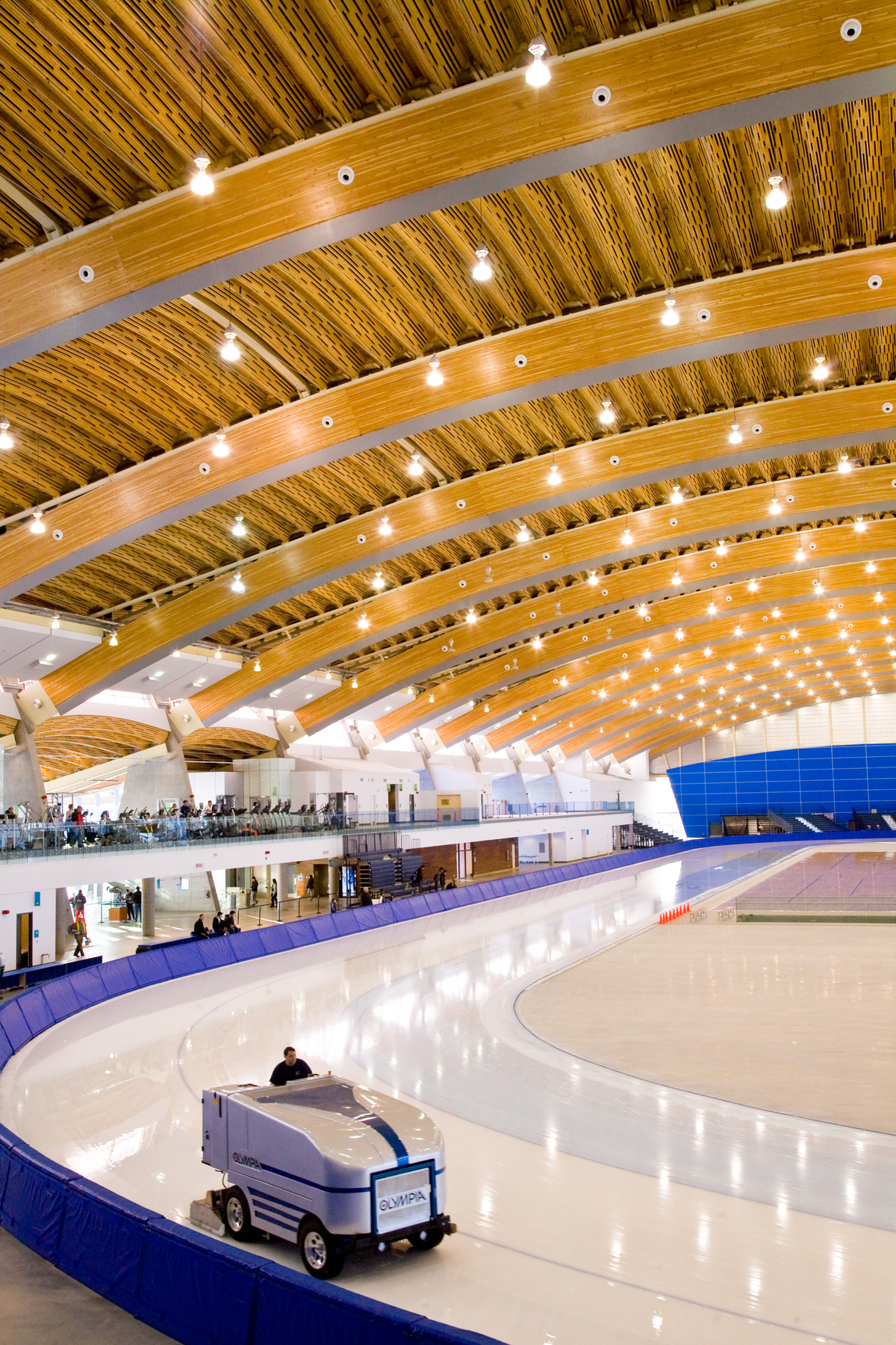 Interior daytime image of glue-laminated timber (Glulam), and wooden roof accents as featured in this interior occupied arena view of the Richmond Olympic Oval complex