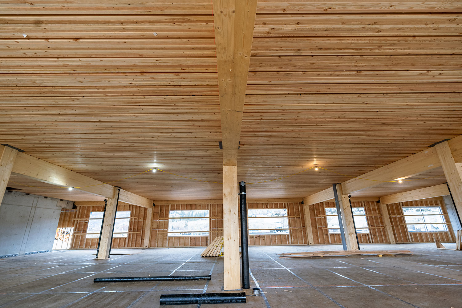 Interior photo of NLT panel roof and glulam beams and columns during the construction of The Exchange